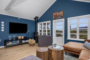 a living room with blue walls and a flat screen tv at Modern 4BR Summerhouse with Sauna and Hot Tub in Selfoss