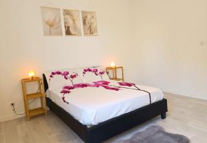 a bedroom with a bed with purple flowers on it at Appartement avec vue exceptionnelle in Blanzat
