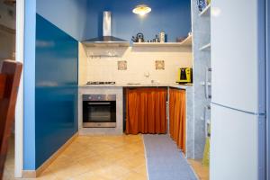 eine Küche mit Herd und orangefarbenem Vorhang in der Unterkunft Solemar Sicilia - Casa Enza in Santa Flavia
