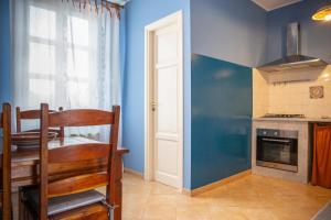 a kitchen with a table and a blue wall at Solemar Sicilia - Casa Enza in Santa Flavia
