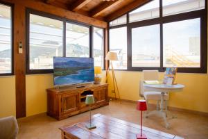 a living room with a tv and a table at Solemar Sicilia - Casa Enza in Santa Flavia