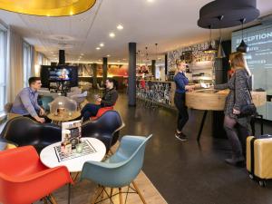 a group of people sitting at a counter in a restaurant at ibis Sint Niklaas Centrum in Sint-Niklaas
