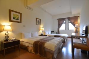 two beds in a hotel room with two lamps at Yago Inn in Tamsui