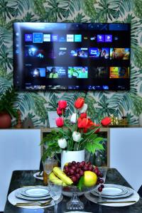 una mesa con un jarrón de flores y fruta en Modern and cozy apartment in the heart of Kenitra, en Kenitra