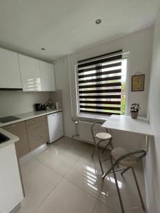 een keuken met een tafel en 2 stoelen en een raam bij Central Park studio in Gulbene