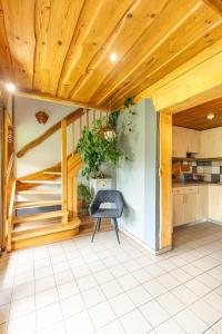 a kitchen with a wooden ceiling and a chair at Sauleskalns in Zaķumuiža
