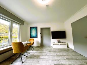 a living room with a table and a tv at Fewo Himmelblau in Burgen