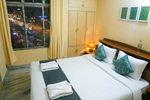 Postel nebo postele na pokoji v ubytování Rooftop Cityscape Inn