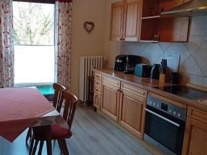 WaldkappelRJS Lambach GbR, Ferienwohnung am Dorfplatz的厨房配有木制橱柜和一张桌子。