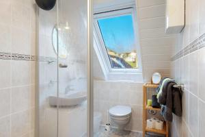 Un baño con ducha, inodoro y ventana. en Ferienwohnung Waldblick, en Simonswald 28 fotos más