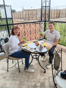 a man and a woman sitting at a table with drinks at Riad Le Bijou de Zahra Marrakech Kasbah in Marrakech
