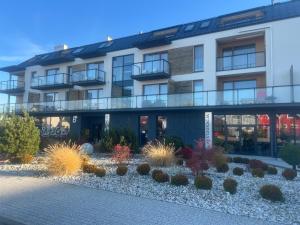 an apartment building with a garden in front of it at Apartament Niebieski Centrum Sarbinowo in Sarbinowo