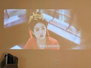 a tv screen with a picture of a woman at 梧舍壹号 外滩百年公寓B&B -Riverside Grace Suites on the bund and metro station in Shanghai