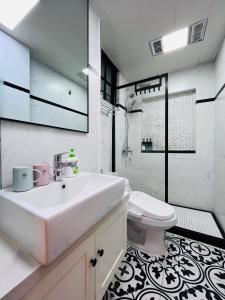 a white bathroom with a sink and a toilet at 梧舍壹号 外滩百年公寓B&B -Riverside Grace Suites on the bund and metro station in Shanghai