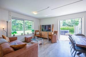 TV a/nebo společenská místnost v ubytování Theislandlife Vakantiehuis met privé jacuzzi en 3 B&B kamers