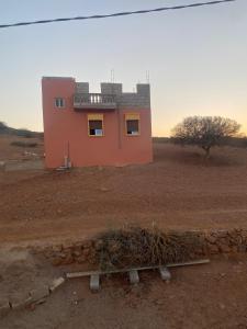 een klein huis in het midden van een veld bij house surrounded by trees in a village in Tiznit
