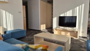 Una sala de estar con un sofá y un televisor. en Golden Tulip Międzyzdroje Residence, en Międzyzdroje