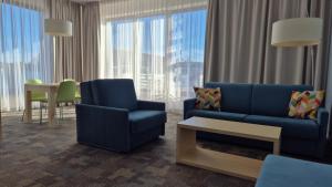 Una sala de estar con un sofá y sillas y una mesa. en Golden Tulip Międzyzdroje Residence, en Międzyzdroje