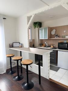 a kitchen with a counter and stools in it at Studio aux portes d'Orly & Paris in Athis-Mons