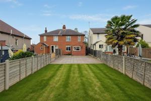 a fence in front of a house with a yard at The Victorian House Escape, Free Private Parking & Wifi, 7 beds in Colchester