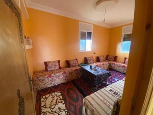 een woonkamer met twee banken en een tafel bij house surrounded by trees in a village in Tiznit