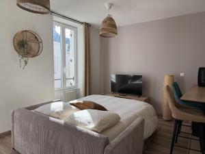 a bedroom with a bed and a table and a television at Au cœur de Vernon - Appartement cosy in Vernon