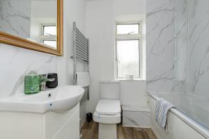 a white bathroom with a toilet and a sink at The Victorian House Escape, Free Private Parking & Wifi, 7 beds in Colchester
