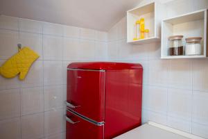 Defstero Asteri في ريجيو إيميليا: ثلاجة حمراء في مطبخ مبلط باللون الأبيض