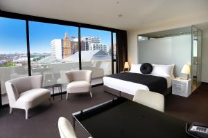 霍索恩区Corporate Living Accommodation Hawthorn的一间卧室配有床和椅子以及大窗户