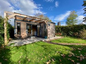 a small shed with a table and chairs in a yard at Tiny House The Cabin in Peize