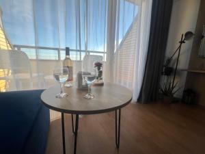 a table with two wine glasses on it in a room at Apartament Niebieski Centrum Sarbinowo in Sarbinowo +16 photos