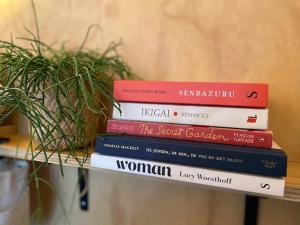 a stack of books sitting on a shelf at Tiny House The Cabin in Peize