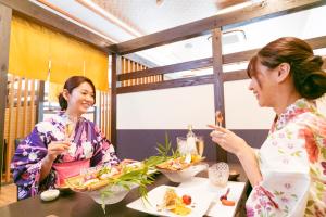 two women sitting at a table eating food at Ureshino Motoyu in Ureshino