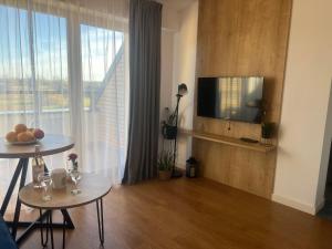 a living room with a television and a table with fruit at Apartament Niebieski Centrum Sarbinowo in Sarbinowo