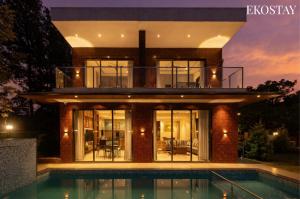 a house with a swimming pool in front of it at EKOSTAY - Terra Cotta Villa in Panchgani +19 photos