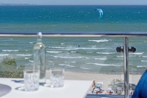 a table with glasses and a bottle on the beach at Hang 13 Wohnung 26 in Scharbeutz