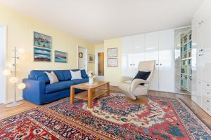 a living room with a blue couch and a chair at Hang 13 Wohnung 26 in Scharbeutz