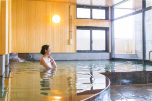 a woman sitting in the water in a swimming pool at Ureshino Motoyu in Ureshino