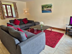 a living room with a couch and a red rug at Hobby Stable Cottage in Cynghordy