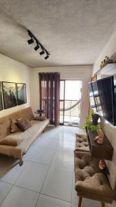 Μια τηλεόραση ή/και κέντρο ψυχαγωγίας στο Apartamento com dois quartos a 300m da praia