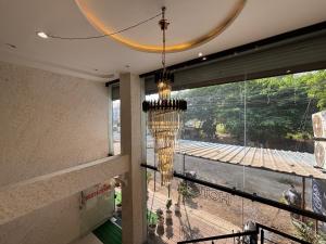 a chandelier in a room with a large window at The Mayfair Hotel in Jāmb