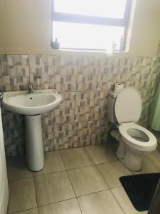 a bathroom with a toilet and a sink at Zalu Lodge in Lusikisiki