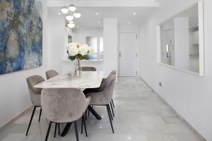 Un comedor con una mesa y sillas blancas. en Balcones del Chaparral Peaceful Seafront by Alfresco Stays, en Mijas Costa