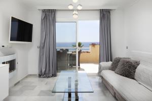 Una sala de estar con un sofá y una mesa de cristal. en Balcones del Chaparral Peaceful Seafront by Alfresco Stays, en Mijas Costa