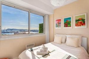 um quarto com uma cama e uma janela grande em Magnifique appartement climatisé vue mer em Toulon