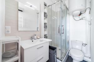 um banheiro branco com vaso sanitário e chuveiro em Magnifique appartement climatisé vue mer em Toulon