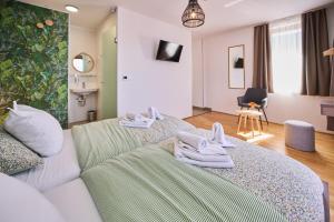 ein Hotelzimmer mit einem Bett, auf dem Handtücher liegen in der Unterkunft ROOMS in Szombathely