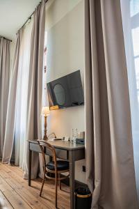 a desk with a chair and a monitor on a wall at ARCHE Klasztor Wrocław in Wrocław