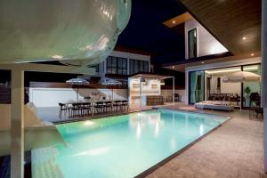 een groot zwembad in het midden van een huis bij Ralph Pool Villa Pattaya in Ban Huai Yai