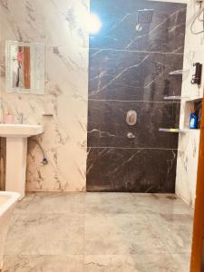 un baño con ducha y lavabo en Bloom Villa, en Mohali 27 fotos más